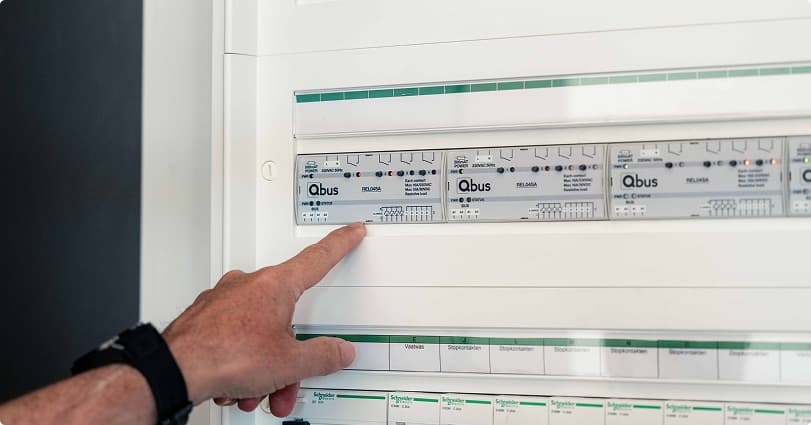 Hand wijst naar componenten in een automatiseringskast