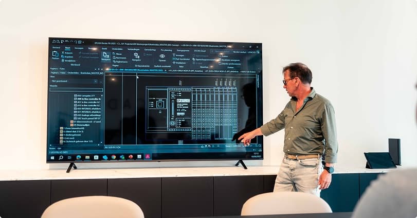 Consultant licht een elektrotechnisch ontwerp toe op groot scherm