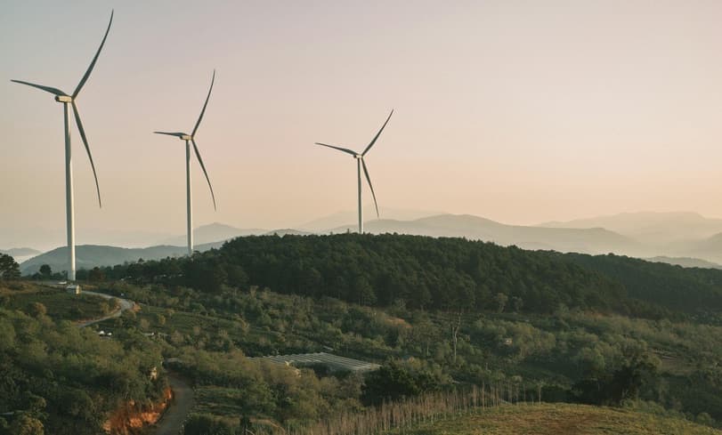 Windturbines in een heuvellandschap bij zonsondergang